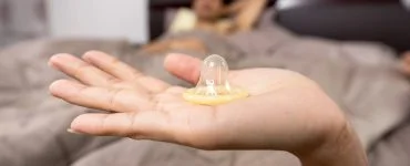 close up of woman holding condom