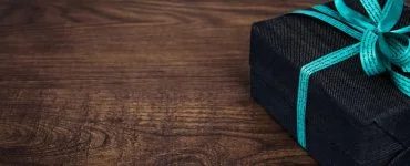 black gift box on wooden surface