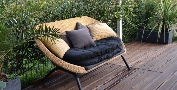 cozy rattan sofa with cushions in tropical garden