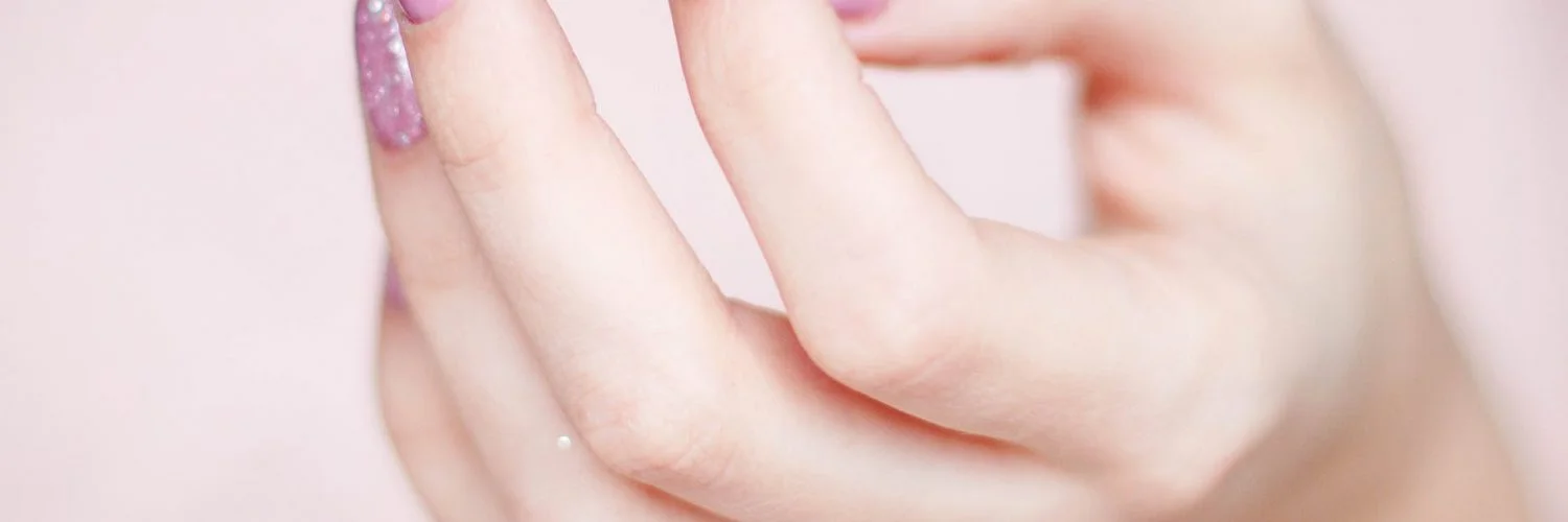 person s hand with pink manicure