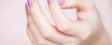 person s hand with pink manicure