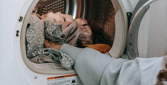anonymous woman loading clothes in washing machine