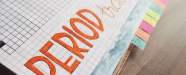 Handgeschreven menstruatiekalender in een notitieboek met ruitjespapier om de cyclus bij te houden