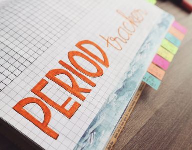 Handgeschreven menstruatiekalender in een notitieboek met ruitjespapier om de cyclus bij te houden